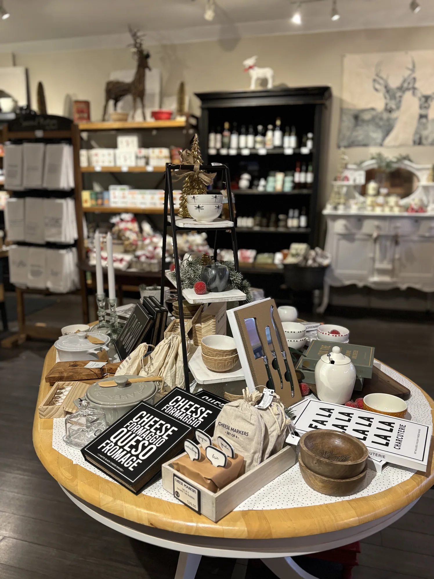 Boutique gift table with cheese books, serving pieces and candles in the shop